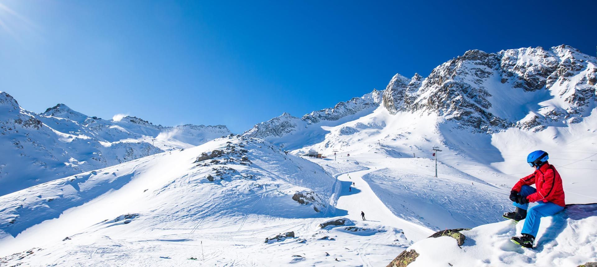 sciatore con attrezzatura noleggiata da noleggio Delpero che osserva le piste del passo Tonale